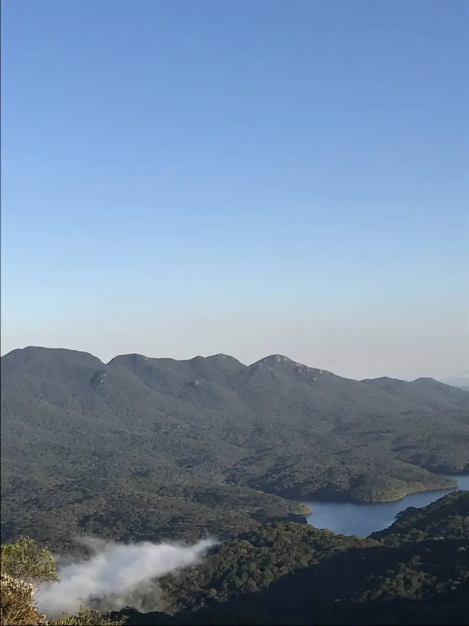 Cadeia de montanhas e represa sob céu azul